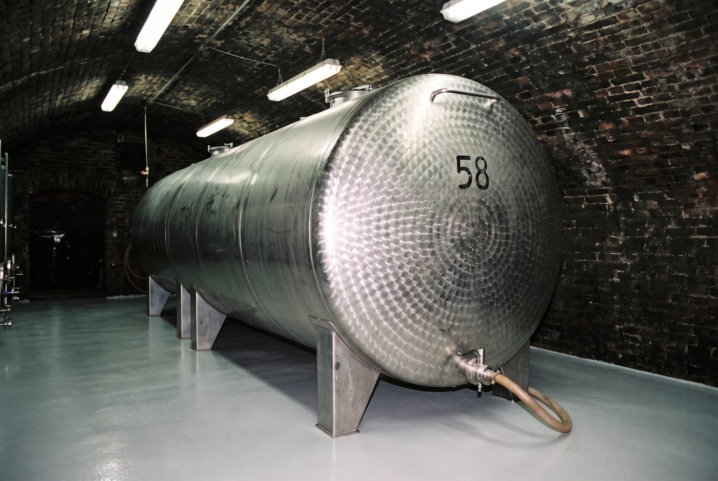 Stainless steel wine tank in a vaulted cellar